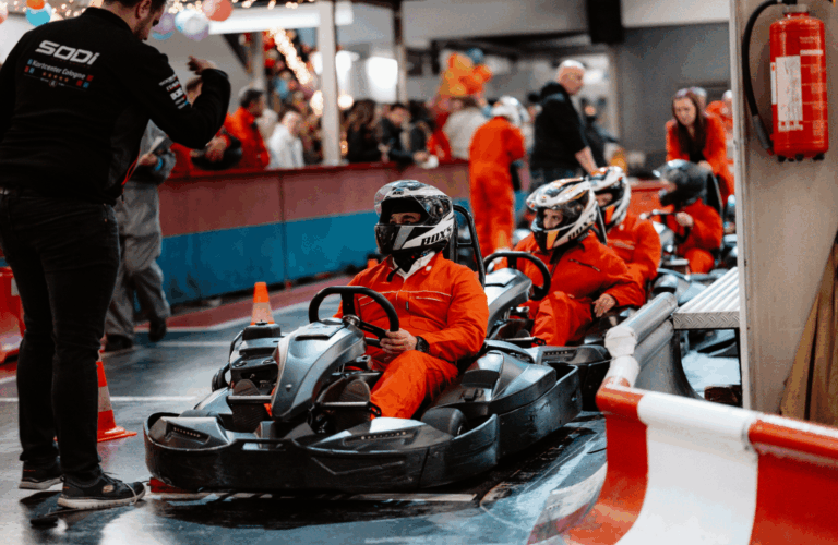 Karts in Startaufstellung im Kartcenter Cologne, Zuschauer beobachten gespannt das Kartfahren Köln.